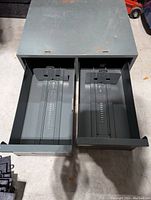 Top view showing two fully open metal drawers inside a gray metal cabinet with internal dividers.