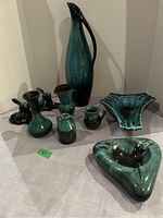 Full display of all pottery items with deer figurines, pitcher, vases, jug, and shaped dishes