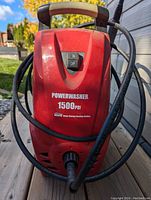 Front view of red Powerwasher pressure washer with on/off switch, label showing 1500 PSI, and attached hose.
