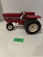 Right side profile of the red International Harvester 3088 toy tractor on a plain background.