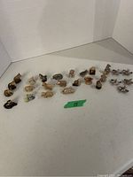 Photo showing arranged Wade Red Rose Tea ceramic animal figurines on a white surface, highlighting the variety of shapes and sizes.