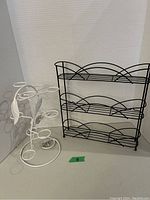 Photo shows black metal spice rack alongside white wire K-cup holder shaped like a tree.