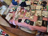 Overview of table showing multiple small boxes with jewelry pieces, handbag at top left