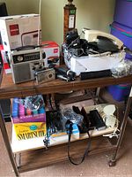 Wide shot showing two-tier shelf loaded with radios, phones, flashlights, speakers and software box