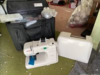 Machine, hard cover, rolling bag and organizer box shown together