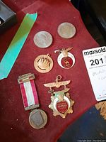 Overview of 6 items including coins and medals on red surface