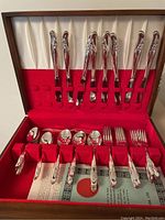 Full view of the Rogers and Son flatware in original wooden case with red velvet holder and cream satin backing, displaying the assorted forks, knives, spoons, and spreading knife.