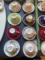 Overview of eight teacup and saucer sets laid out