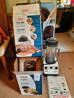 Overall view: blender base assembled next to dry and wet blade container boxes and manual.