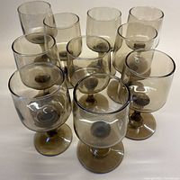 View showing all 10 smoky brown wine glasses arranged closely together, highlighting their consistent color and shape.