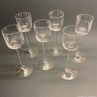Full set of 6 KROSNO stemmed crystal shot glasses, arranged in a group on a dark surface to show clear crystal and shape with some decals visible.