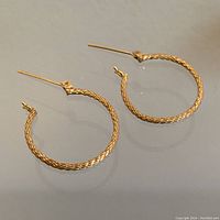 Overview of both textured hoop earrings laid flat