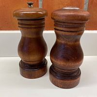 Photo of pepper grinder and salt shaker side by side, showing wood finish and shape