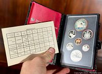 Front view of coin set in leather folio showing coin arrangement and specifications card