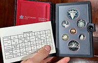 Front view of the open black leather folio showing the 1982 Canadian Proof Coin Set in protective plastic holders along with the specification card open to details.