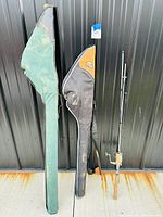 Three fishing rods side by side, two with cases and one rod with cork handle visible