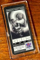 Front view of the VIP opening night pass ticket sealed in a lucite protector showing player shooting.