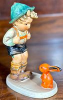 Front view of the Hummel Sensitive Hunter figurine showing the boy looking down at an orange rabbit on an oval base.