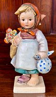 Front view of the hand-painted Goebel Hummel figurine "Weary Wanderer" showing detailed facial features, clothing, and items held.