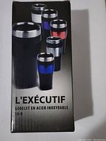 Photo of boxed stainless steel coffee cups with rubberized grips in black with blue and red accent bands shown