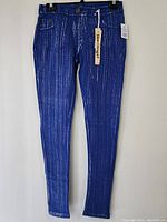 Full length front view of blue women's dressy pants showing vertical silver stripes and cuffed hems.