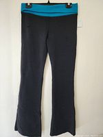 Full front view of the black pants with wide contrasting sky blue waistband