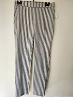 Front view showing full length of striped black and white pants with waistband and belt loops.