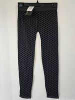 Full front view of the women's patterned pants hanging showing overall design and length