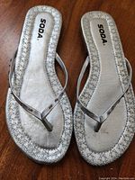 Top view of silver SODA women's sandals, showing footbed and thong strap style with stud details.