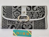 Front view of grey wallet purse with black script print and silver trim showing overall design and attached brand tag.