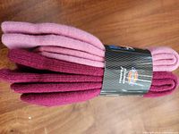 Two pairs of Dickies thermal socks stacked, one burgundy and one pink, wrapped with a branded band.