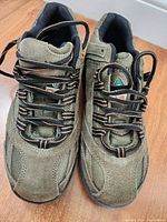 Front angled view of taupe TERRA work shoes on wooden floor, shoes lined up side by side with laces tied loosely.