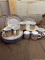 Full set of Dansk International Designs LTD Fiance Fruits dinnerware including plates, soup bowls, mugs, creamer, and sugar bowl arranged together.