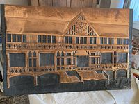 Front view of vintage copper relief artwork depicting detailed building facade with multi-window and entry details.