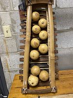 Full view of the balafon showing the wooden frame, ten large resonator gourds, and slats arranged horizontally