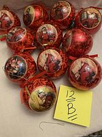 Twelve vintage Victorian style Christmas baubles grouped on white surface showing various illustrations of Santa Claus and children, mostly red with gold accents and glossy finish.