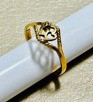 Close-up photo of the 10K yellow gold ring showing the heart-shaped openwork design with small flower detail.