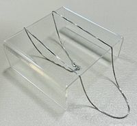 Necklace draped on clear acrylic stand showing overall length and chain style