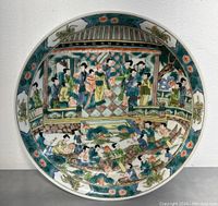 Top-down view of shallow bowl interior showing figural and floral wucai enamel decoration.