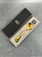 Spoon in original black box with gold embossed Danish crown logo. Spoon is gold plated and measures approximately 6 inches.