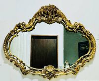 Front view of vintage Italian Baroque style large gold wall mirror on a white wall.