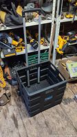 Fully extended folding trunk cart showing telescoping handle and wheels on a wooden floor in a tool storage area.