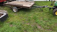 Side view of small flatbed trailer on grass
