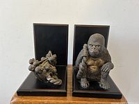 Front view of the two bookends side by side showing the gorilla family sculptures mounted on the black wooden bases.