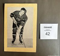 Front of the vintage black and white hockey photo of Doug Harvey, mounted on cream colored backing, showing the player's name printed on the photo.