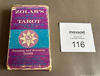 Original purple and blue cardboard box for Zolar's New Astrological Tarot cards showing worn edges and surface wear.