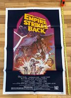 Front of Empire Strikes Back movie poster measuring 26.5 inches by 40 inches, colorful illustration of characters and title