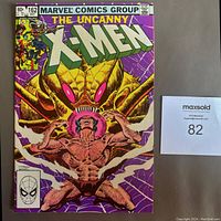 Front cover of The Uncanny X-Men #162 comic showing a muscular character in front of a giant insect web structure with purple background.