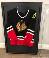 Jersey displayed inside the black backing and clear acrylic panel showing the display case setup and size.