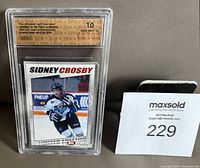 Photo showing Sidney Crosby rookie card encased in plastic holder with SPA grade label and card visible.